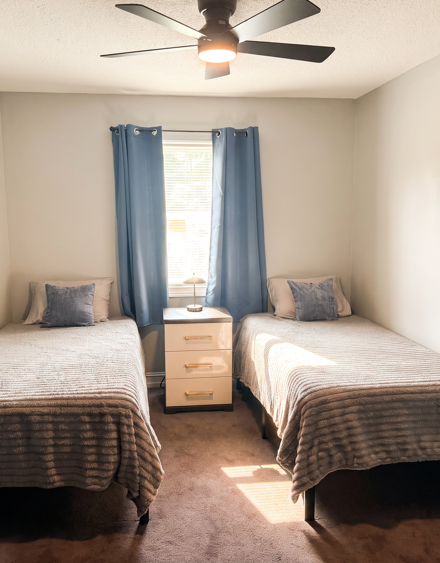 The same twin bedroom with a natural daylight look: same beds, same small window